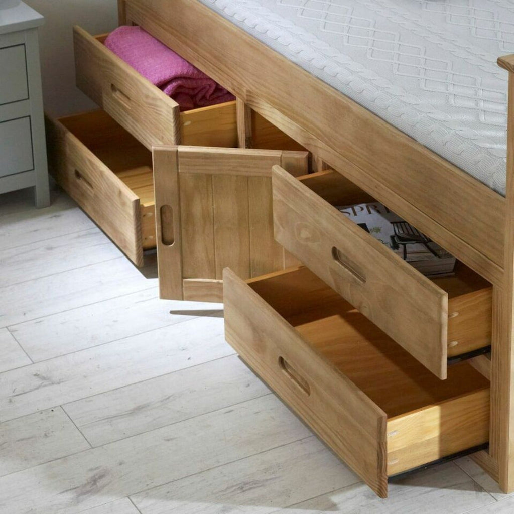 Captains Wooden Underbed Storage Bed - Close up of Captain's bed in waxed pine, doors and drawers slightly open, positioned at an angle in a grey bedroom - Beds4Us