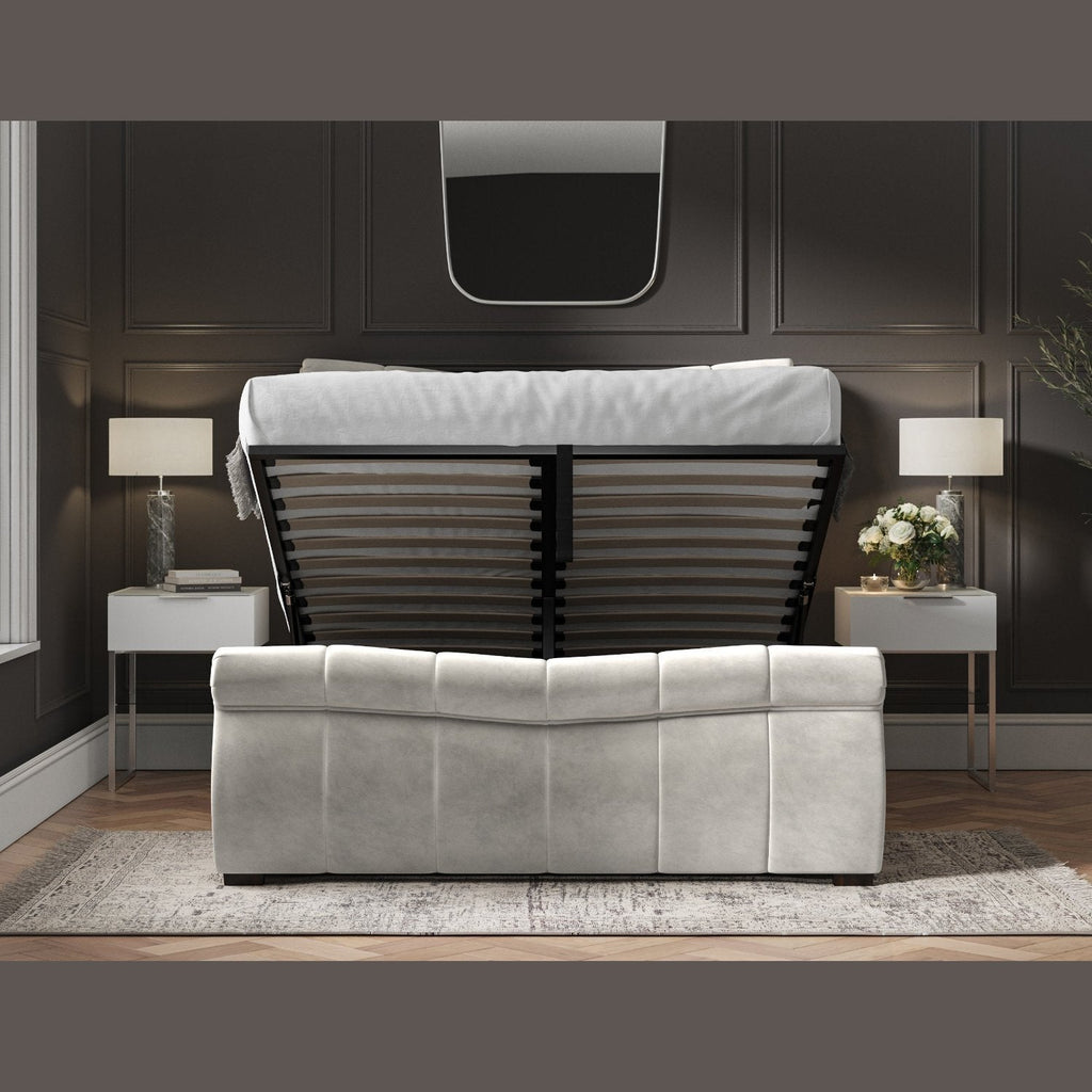 Bosworth Fabric Ottoman Storage Sleigh Bed  - Light grey sleigh ottoman bed frame positioned face on, ottoman base lifted up, in a dark modern room - Beds4Us