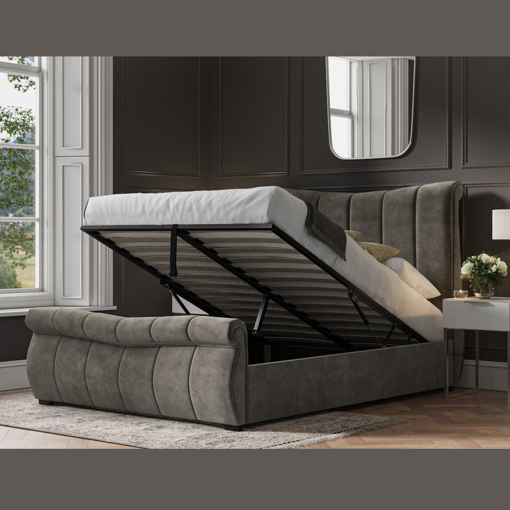 Bosworth Fabric Ottoman Storage Sleigh Bed  - Dark grey sleigh ottoman bed frame positioned at an angle, ottoman base lifted up, in a dark modern room - Beds4Us