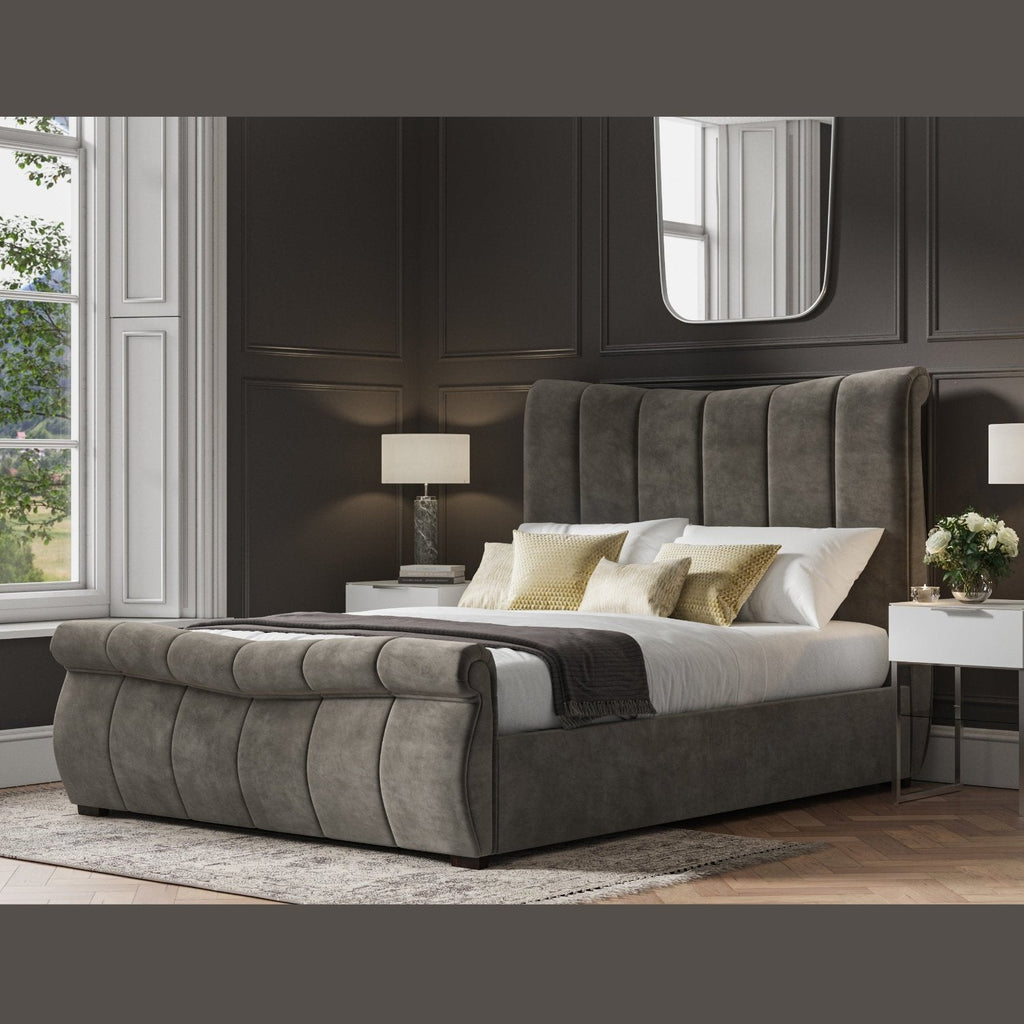 Bosworth Fabric Ottoman Storage Sleigh Bed  - Dark grey sleigh ottoman bed frame positioned at an angle, in a dark modern room - Beds4Us