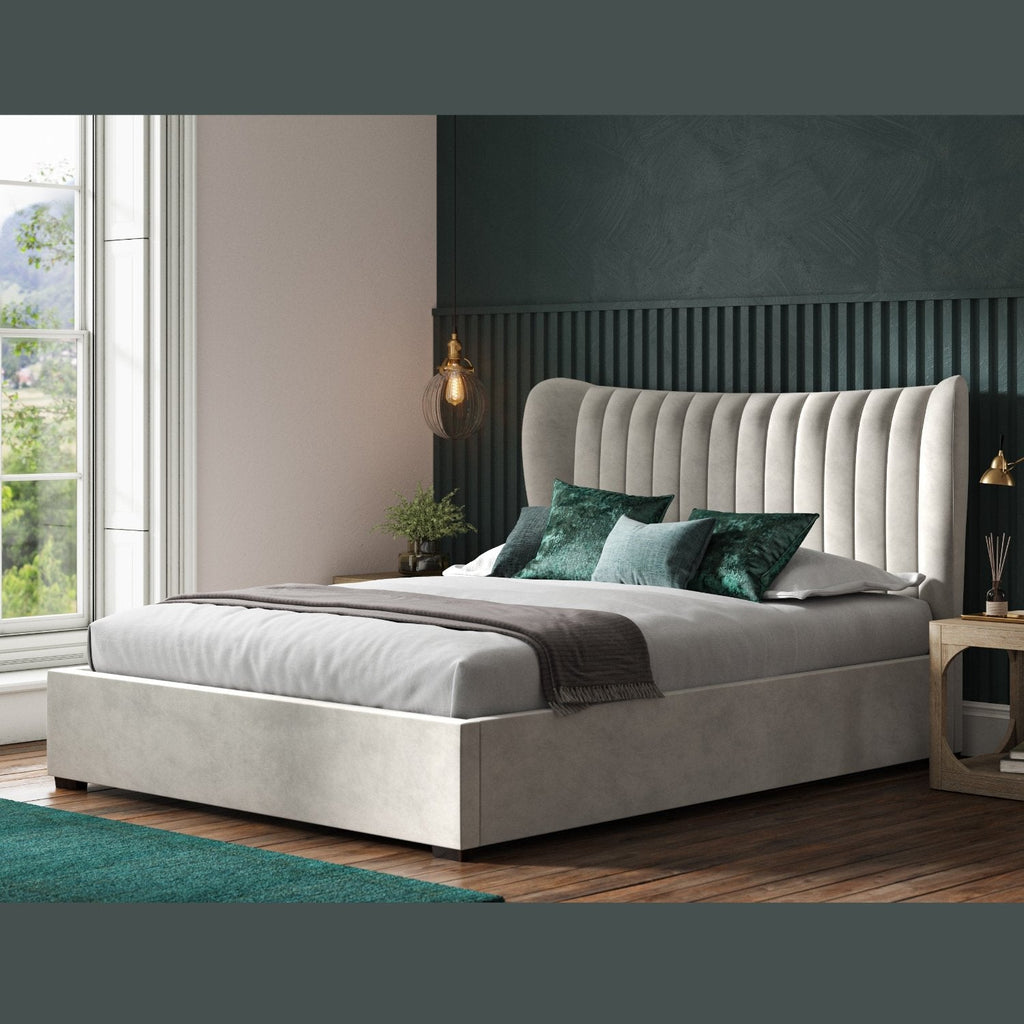 Harcourt Winged Fabric Ottoman Storage  Bed  - Light grey ottoman bed frame positioned at an angle, in a dark modern room - Beds4Us