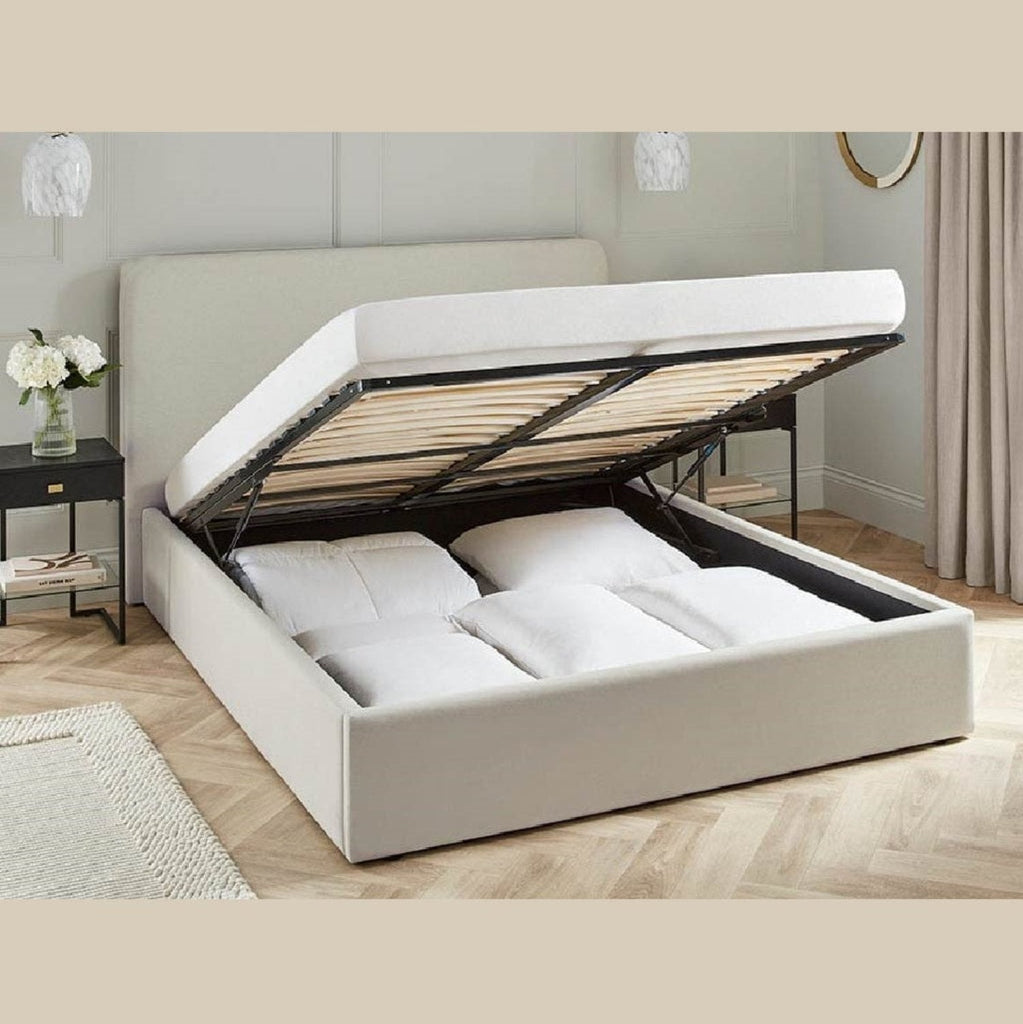 Glasgow Fabric Ottoman Storage Bed - Oat coloured fabric ottoman bed frame positioned at an angle, storage ottoman open, in a bright modern room - Beds4Us