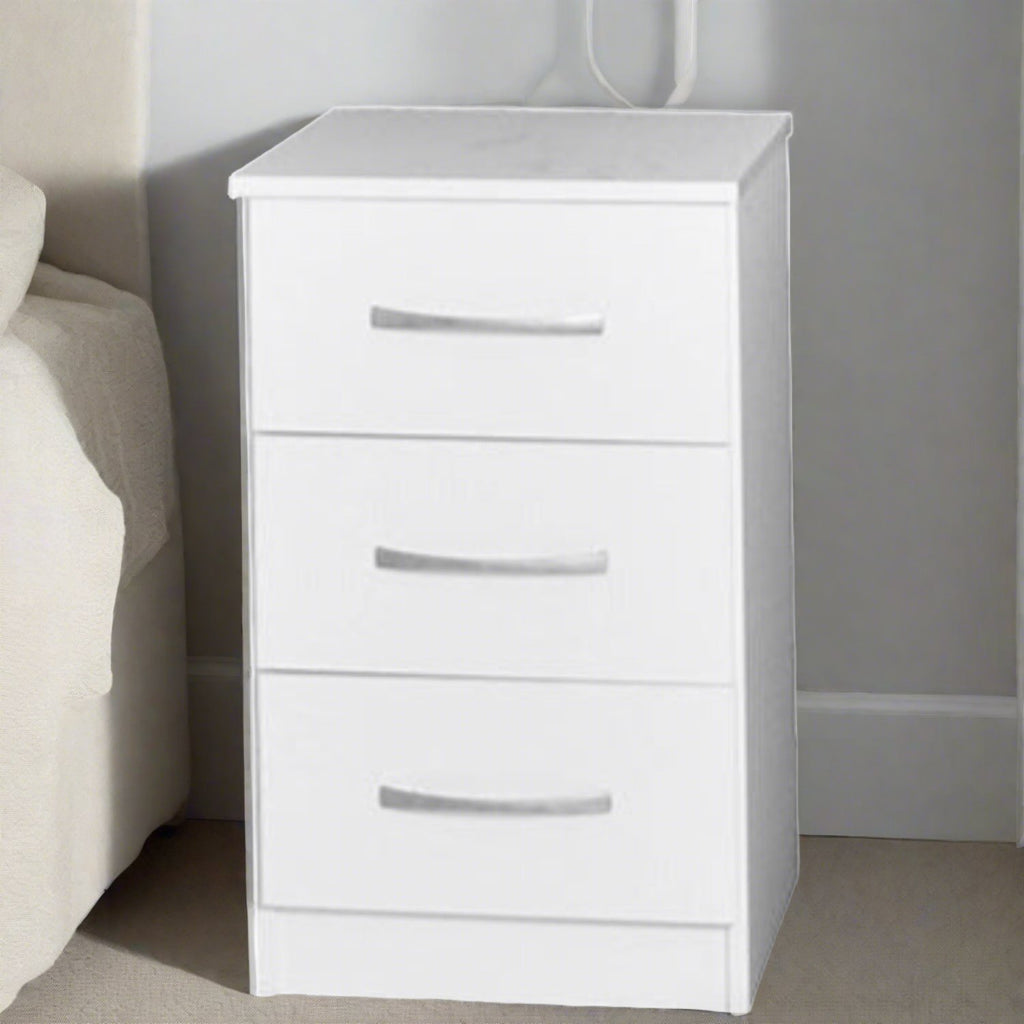 JJ 3 Drawer bedside - White bedside chest with 3 drawers and silver handles, enlarged in a grey and beige bedroom next to the bed- Beds4Us