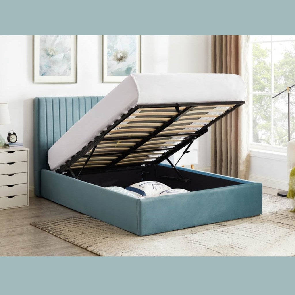 Sky Fabric Ottoman Storage Bed - Sky blue coloured velvet fabric ottoman bed frame positioned at an angle, storage ottoman open, in a bright modern room - Beds4Us